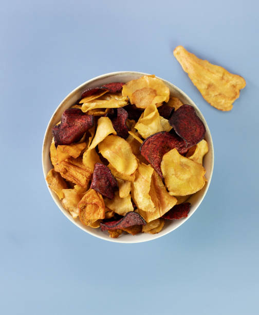 istock A bowl of vegetable organic chips made from beets, carrots and celery root on a gray background. Top view. 1997336944