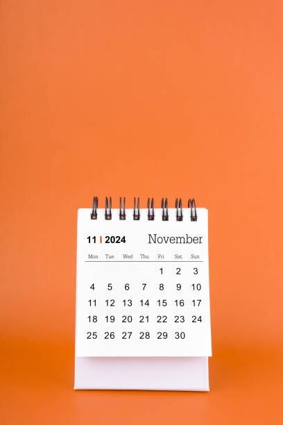 istock Vertical of November 2024 table calendar on orange background. 1997344035