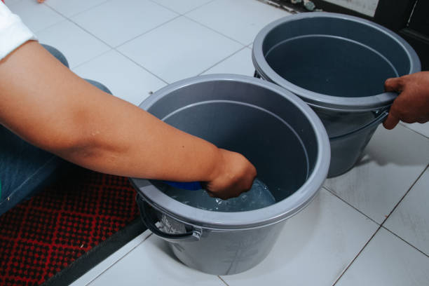 istock a person cleans his hands by putting his hands in a bucket 1997349842