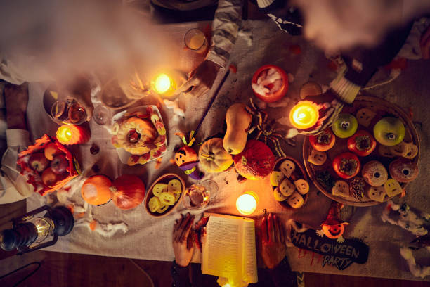 istock Above view of unrecognizable people at dining table on Halloween. 1997362372