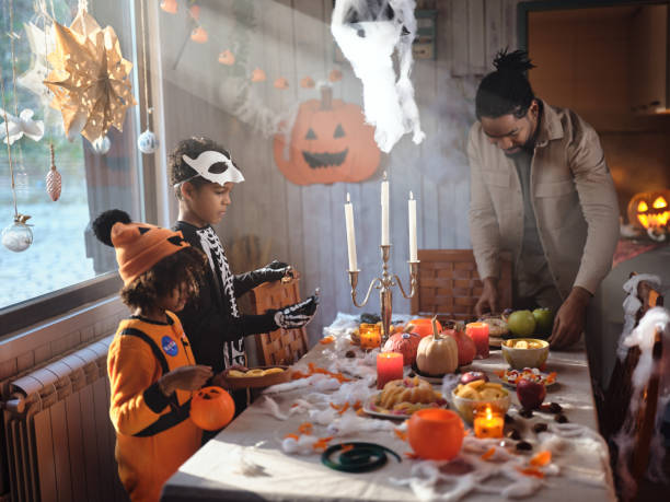 istock Black father and his kids setting the table for Halloween party. 1997365005