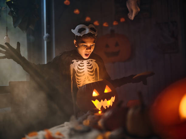 istock Shocked black boy looking inside of illuminated Jack O' Lantern on Halloween. 1997378656