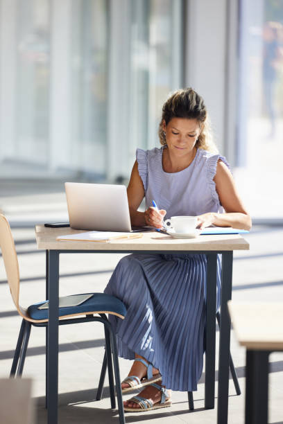 istock Young businesswoman taking notes while working on laptop in the office. 1997405028