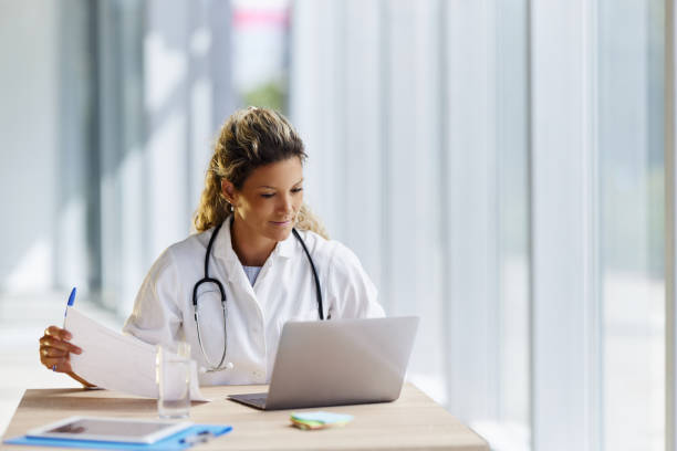 istock Young female doctor working on documents and laptop in the office. 1997406106