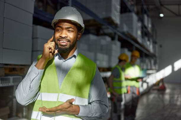 istock Happy black manager talking on cell phone in distribution warehouse. 1997438823