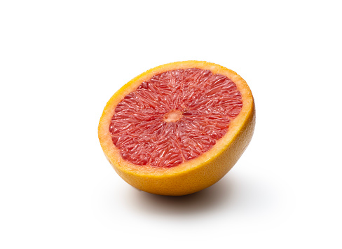 This is a close up photo of pink grapefruit sliced in half that is isolated on a white background with a drop shadow. High angle view, studio shot.