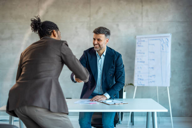 Smiling businessman shaking client hand, closing successful deal in office