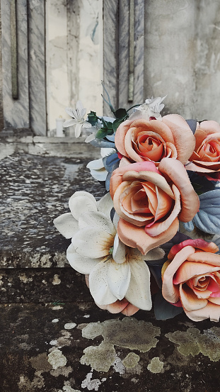 fake flowers in a country cemetery, a sad, poetic and slightly retro image
