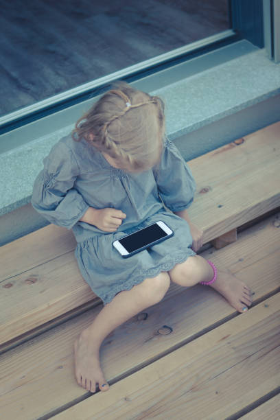 sweet little girl is playing with the smart phone.