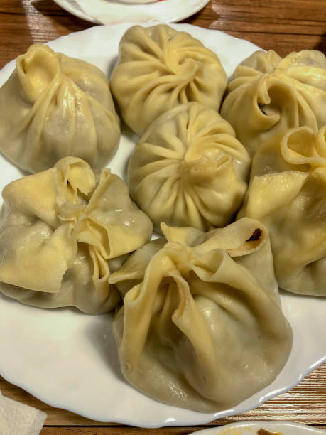 istock Steamed chinese dumplings on a plate on wooden table 1997491245
