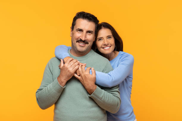 istock Glad european old woman embraces man from behind with a joyful expression, both smiling 1997495556