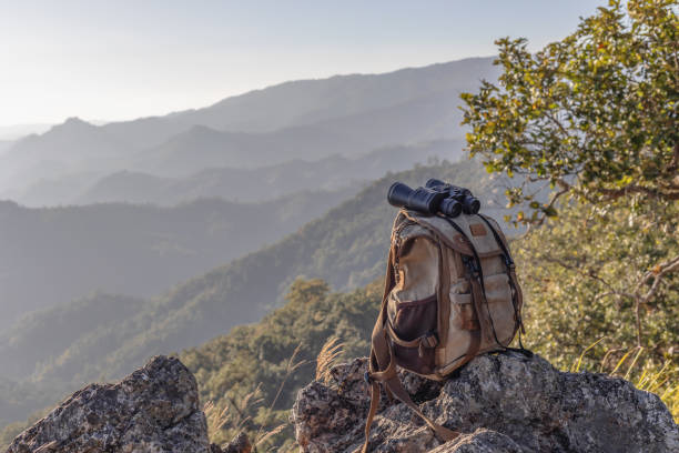 istock Binocular with backpack on top of rock mountain at sunset 1997498560