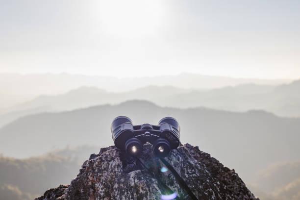 istock binoculars on top of rock mountain at beautiful sunset background. 1997498788