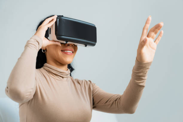 istock Young woman using virtual reality VR goggle at home for crucial experience 1997502445