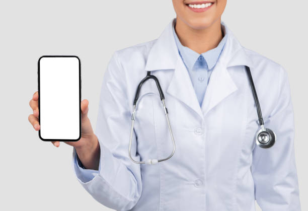 istock A smiling female doctor in a lab coat presents a smartphone with a blank screen 1997512032