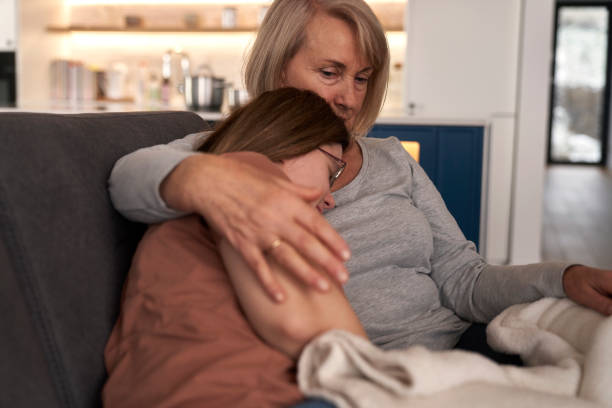 istock Mother embracing down syndrome woman lying down on sofa 1997512079