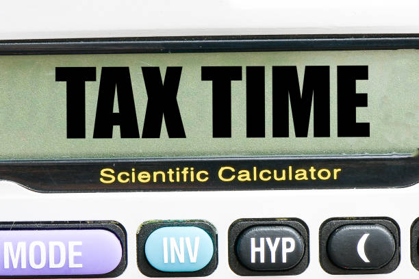 A fisheye image of a frustrated woman holding tax forms and a calculator.