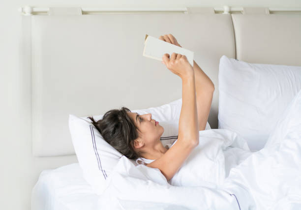 istock Woman  reading book in the bed 1997567874