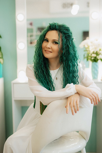 portrait of a bride with green curly hair in the morning in the beauty room