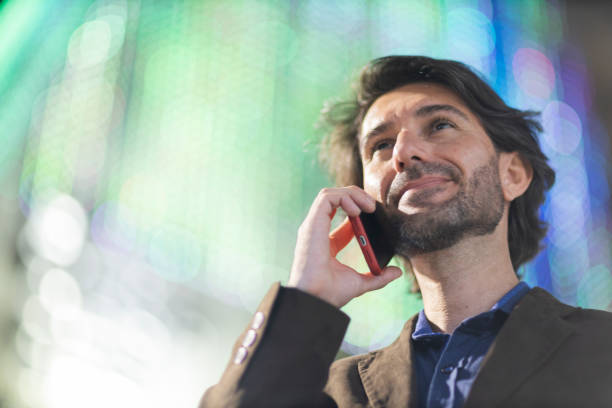 View of young man using a smartphone at night time with city view landscape in the background. High quality photo. View of young man using a smartphone at night time with city view landscape in the background. High quality photo.