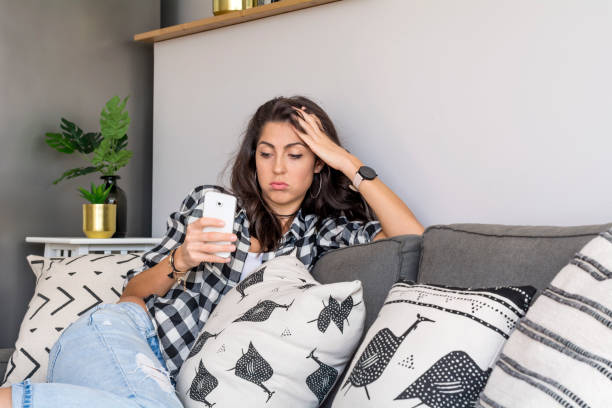 istock Sad Woman  using her phone at home 1997589342