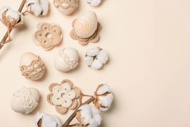 istock Craft eggs, knitted and cotton flowers on soft beige background. Top view. Copy space 1997598882