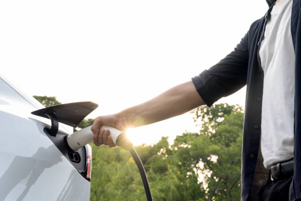 istock Man recharging battery for electric car during road trip. Exalt 1997620695