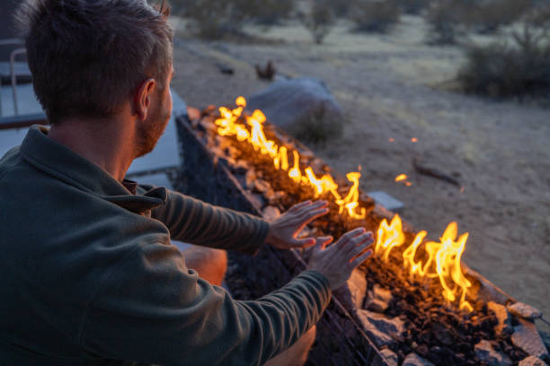 istock Young man by the fire pit outdoors at dusk 1997625953