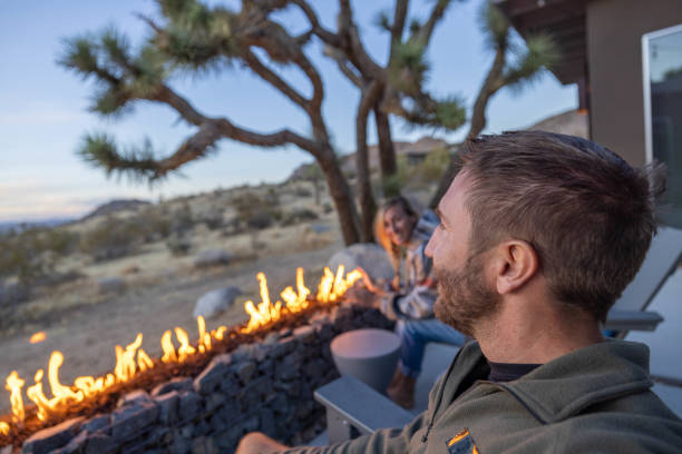 istock Young couple by the fire pit outdoors at dusk 1997625965