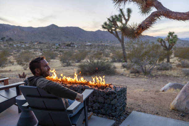 istock Twilight Serenity: A Young Man's Reflection by the Outdoor Fire Pit 1997626495