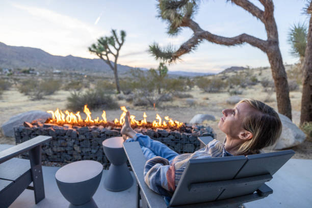 istock Young woman by the fire pit outdoors at dusk 1997627022