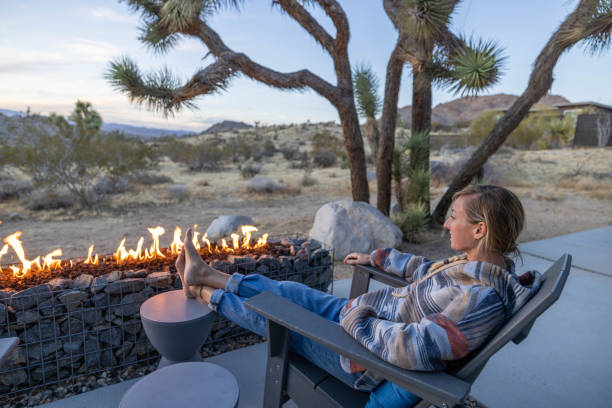 istock Young woman by the fire pit outdoors at dusk 1997627550