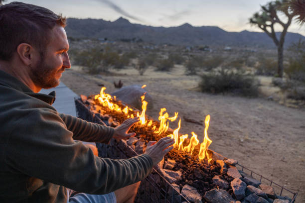 istock Dusk's Hearth: A Young Man's Contemplation by the Outdoor Fire Pit 1997627551