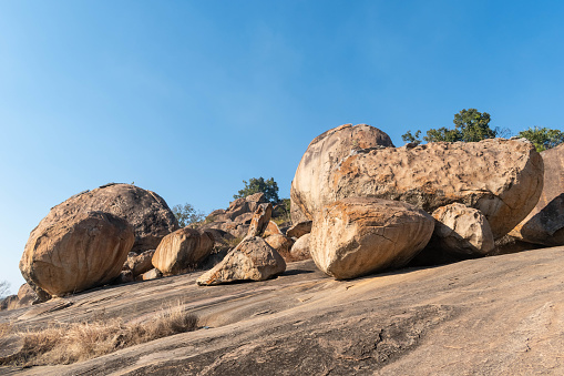 This image captures the serene beauty of large granite boulders set against a clear sky on a gentle slope in Shravanabelagola, reflecting the natural landscape of the region.