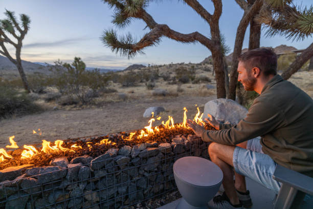 istock Dusk's Hearth: A Young Man's Contemplation by the Outdoor Fire Pit 1997627979