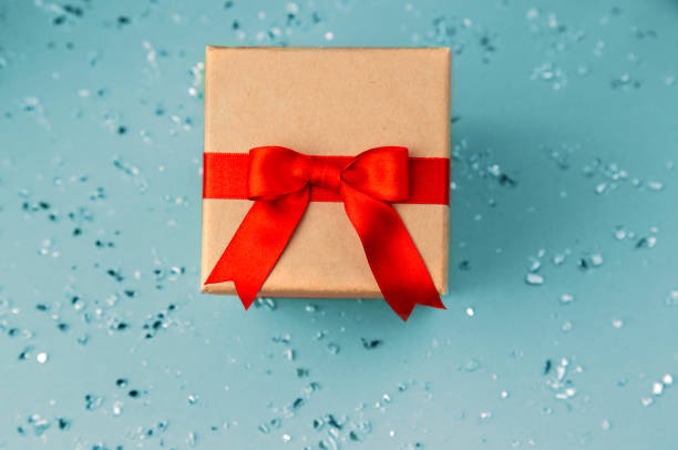 istock beige gift box with red ribbon top view on soft blue pattern background isolated, cut out, copy space 1997633397