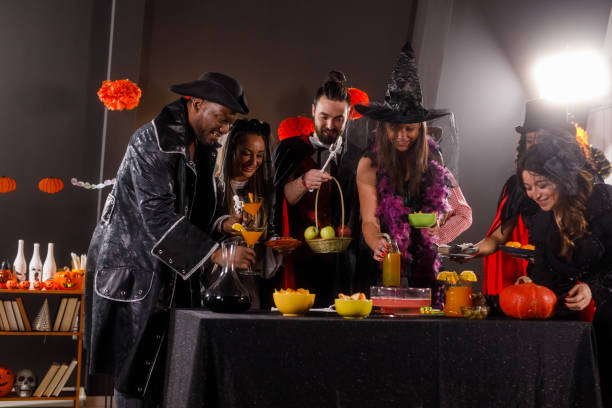istock Group of friends serving drinks and snacks for a Halloween party 1997654516