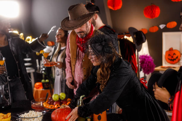 istock Group of friends serving drinks and snacks for a Halloween party 1997654532