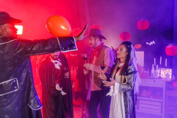 istock Friends playing with a balloon and dancing during a fun Halloween party 1997656685