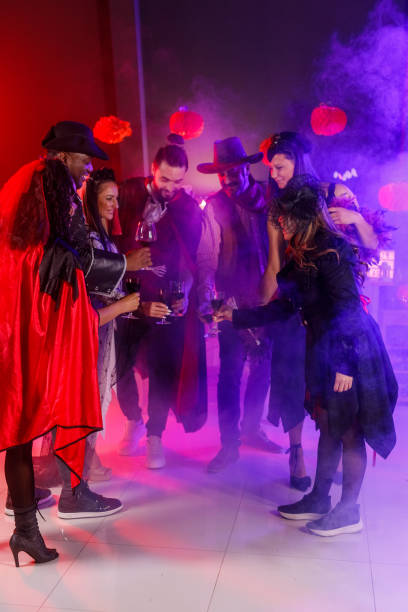 istock Friends playing with a balloon and dancing during a fun Halloween party 1997656691