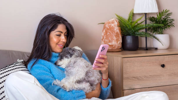 istock Smiling Woman using her phone at home 1997657235