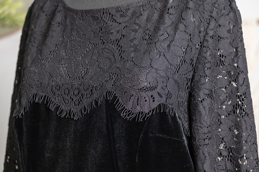 Close-up of a black lace bodice on a woman's velvet dress. Side view. Demonstration of clothes in an online store.