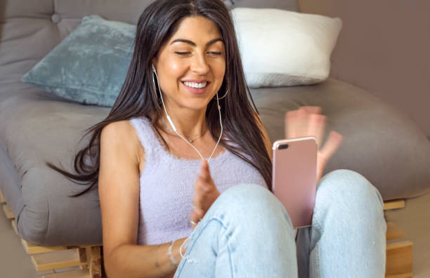 istock Smiling Woman using her phone at home 1997668990