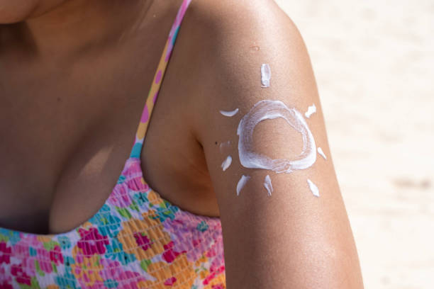 istock A woman applying sun-shaped sunscreen on her arms while sitting on a beach in Thailand. 1997670721