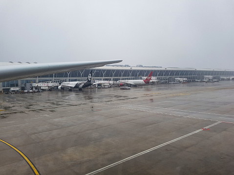 Shanghai, China - march 20, 2017 - view of the ramp of Shanghai Pudong International Airport in cloudy and rainy weather and the presence of planes of different airlines on the international ramp of this airport, air new Zealand, virgin atlantic