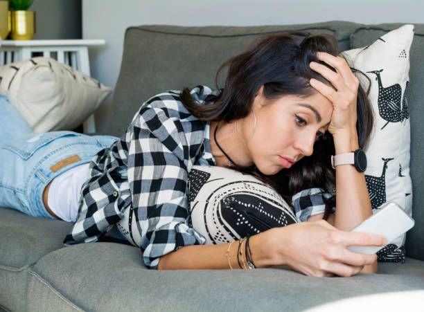 istock Sad Woman  using her phone at home 1997679273