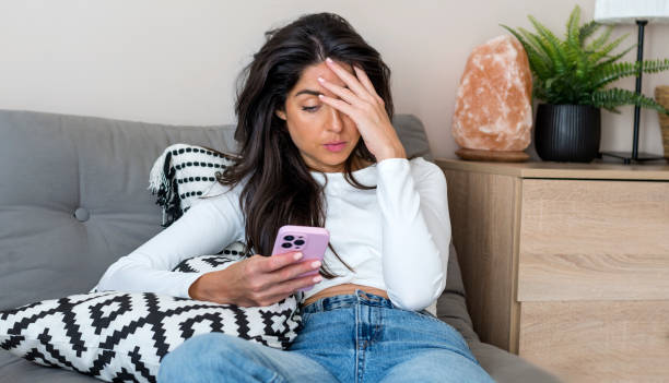 istock Sad Woman  using her phone at home 1997681445
