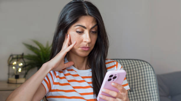 istock Sad Woman  using her phone at home 1997694527