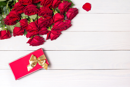 Festive background for Valentine's Day with a bouquet of red roses and a decorative house, copy space.