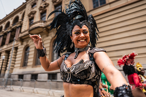 Portrait of a mature woman having fun and dancing at a street carnival party